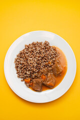 Boiled buckwheat with meat and sauce on white dish