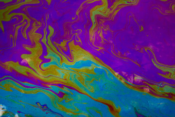 Fototapeta na wymiar colored stains of gasoline oil on the water, iridescence