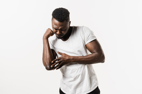 Elbow Injury Causing Pain, Swelling, Stiffness, And Limited Movement. Fractures, Dislocations, Sprains, And Tennis Elbow. Elbow Injury Of African American Man Isolated On White Background.