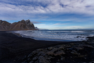 montagne d'Islande enneige  avec vue sur mer au bord d'une plage de sable noir  prise au grand angle donnant une perspectivement d'immensité et de solitude
