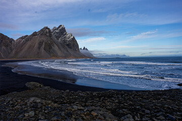 montagne d'Islande enneige au bord d'une plage de sable noir  donnant une perspectivement...