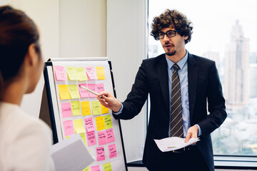 Businessman leader in marketing coaching interested business people, giving educational workshop presentation in modern office.