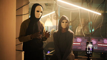 Cyber criminals wearing anonymous masks broadcasting video to make threat, asking money as ransom....