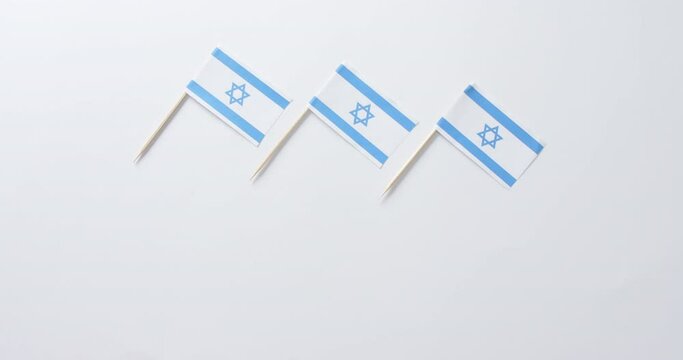 Close up of three flags of israel lying on white background with copy space
