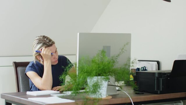 tired bored female in blue sit desk computer monitor woman hold pen look ceiling, touching head sleepy listening online class webinar boring speech tutor concept student e-learning distant work indoor