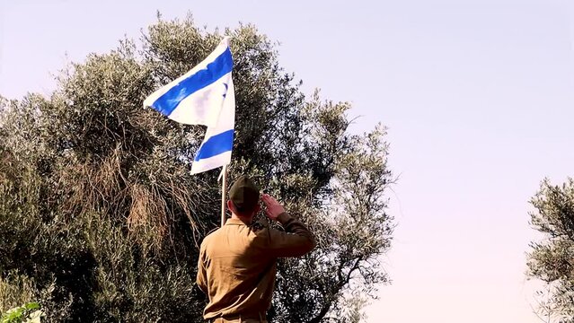 Israeli Army Soldier saluting the Flag of Israel. Themes: Holocaust Memorial Day, Israel Independence Day, IDF, Army, Soldiers, military, uniform
