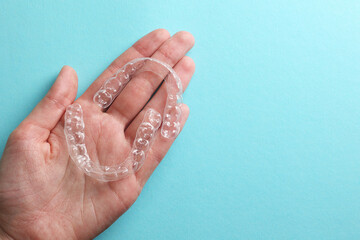 Aligners for aligning teeth on a blue background in a female hand