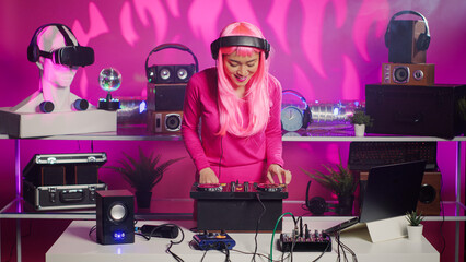 Asian performer mixing and mastering techno sound using professional turntables, enjoying performing music during night party in club. Dj artist doing performance with audio equipment