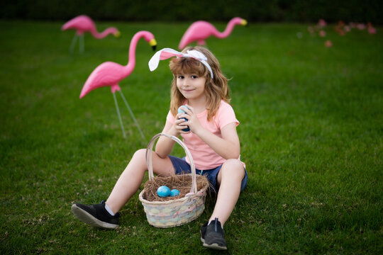 Easter kid in park. Child in bunny ears hold Easter egg. easter basket Boy hunting easter egg. Easter egg hunt.