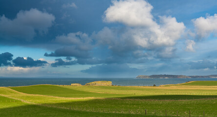 Scenic view of green fields above the sea along the Antrim Coast