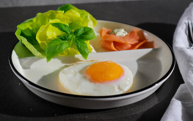close up of ketogenic breakfast with fried egg, green salad and smoked salmon