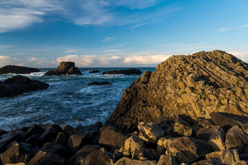 Rocky coastline and sea in dramatic light at sunset - Ballintoy Harbor, Northern Ireland