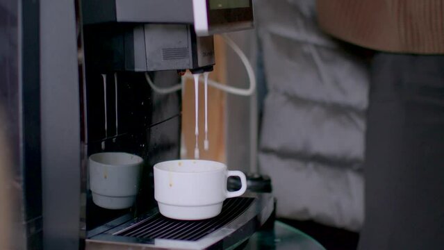The coffee machine is broken. Close-up of a cup filled with liquid and foam with milk delivery problems.