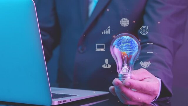 Businessman shows human brain inside glowing light bulb for creative thinking, inspiration and imagination idea concept. AI artificial intelligence, machine learning concept and innovative technology.