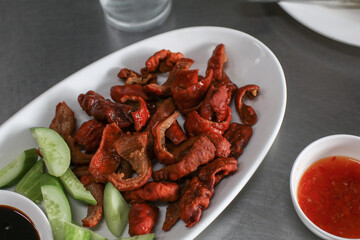 Fried duck intestines in white plate. Thai fried food. Tasty and good with drinks.