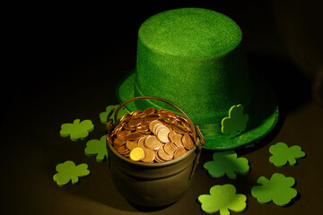 St. Patrick’s day, pot of gold coins, leprechaun hat and shamrocks, on black background