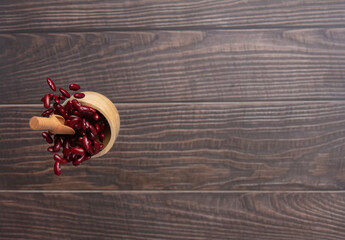 Red Bean flying explosion in wood bowl, red grain beans explode abstract cloud fly. Beautiful complete seed pea bean bowl splash in air, food object design. Wooden background isolated freeze shot