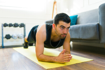Attractive fit man doing a plank during his home workout