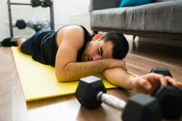 Tired young man exhausted from his home workout