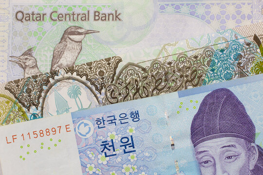 A blue one thousand won note from South Korea placed with a colorful riyal from Qatar