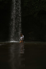 Obraz premium Woman tourist at a waterfall in the tropical jungle, Bali.