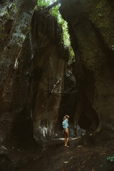 Woman tourist at a waterfall in the tropical jungle, Bali.
