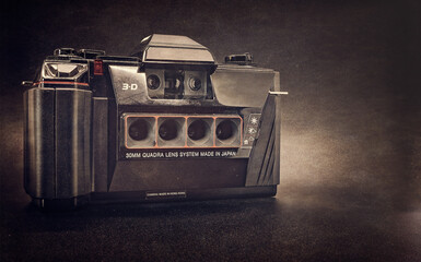 Old Vintage retro 3D camera on a black and sepia background
