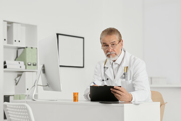 Doctor with patient's medical card at table in clinic