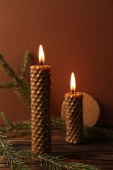Fototapeta na wymiar Stylish elegant beeswax candles with spruce branches on wooden table