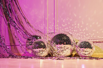 Shiny disco balls and foil fringe curtain indoors, color toned