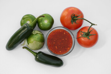 Bowl with delicious salsa sauce and ingredients on white background, flat lay