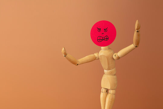 Wood model with anger  and fury concept, on brown background.