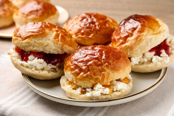 Obraz na płótnie Canvas Freshly baked soda water scones with cranberry jam and butter on table, closeup