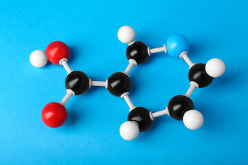 Molecule of vitamin B3 on light blue background, above view. Chemical model