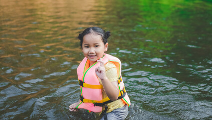 little girl playing in water By wearing a life jacket for safety
