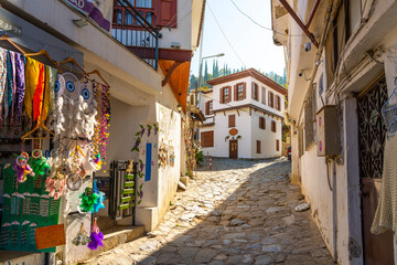 A narrow stone hillside alley with shops and homes in the ancient village of Sirince, Turkey.