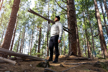 Obraz premium Hombre cargando troncos de madera en un bosque de forma erguida 