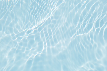 Bluewater waves on the surface ripples blurred. Defocus blurred transparent blue colored clear calm water surface texture with splash and bubbles. Water waves with shining pattern texture background.
