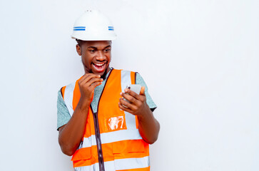 Thrilled male african construction worker looking at mobile phone in hand