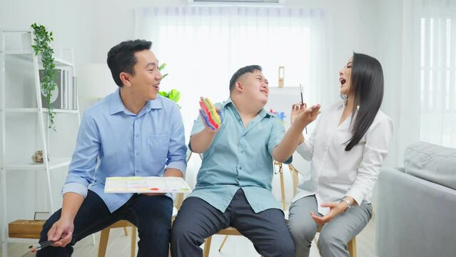 Portrait of Asian happy family, parents draw picture with young son. 