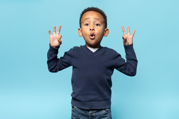 Excited black boy showing ok gesture with both hands and looking at camera with surprised...