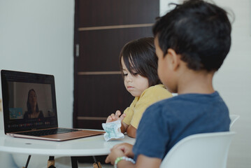 Children focused on their online classes with their teacher