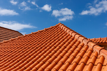 Red tiles panels roof under blue sky. - Powered by Adobe