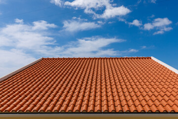 Red tiles panels roof under blue sky. - obrazy, fototapety, plakaty