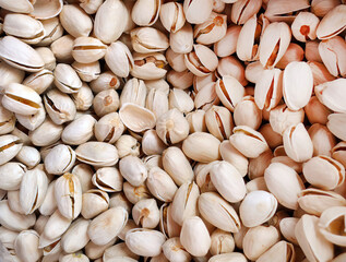 Top view, close up raw cracked unpeeled pistachios, nut background, situated arbitrarily, Natural texture, food background