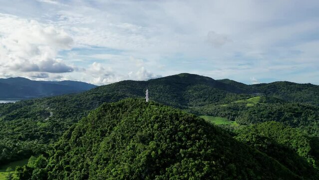 Rotating, Establishing Drone shot of island lighthouse on top of jungle-covered hills in Bato, Catanduanes.