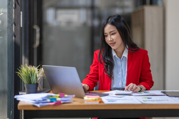Fototapeta premium Businesswoman working at office with documents on desk, doing planning analyzing the financial report, Asian woman business plan investment, finance analysis concept