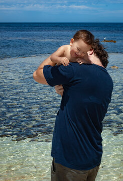 Father making his son laugh at the beach of Pondalowie Bay in the background at Innes National Park, Australia.