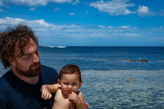 Portrait of a concerned father and unimpressed son with the cliffs of Pondalowie Bay in the background at Innes National Park, Australia.