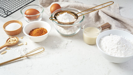 Baking background, pastry or cake ingredients, sifting flour, brown sugar, eggs and milk with utensil